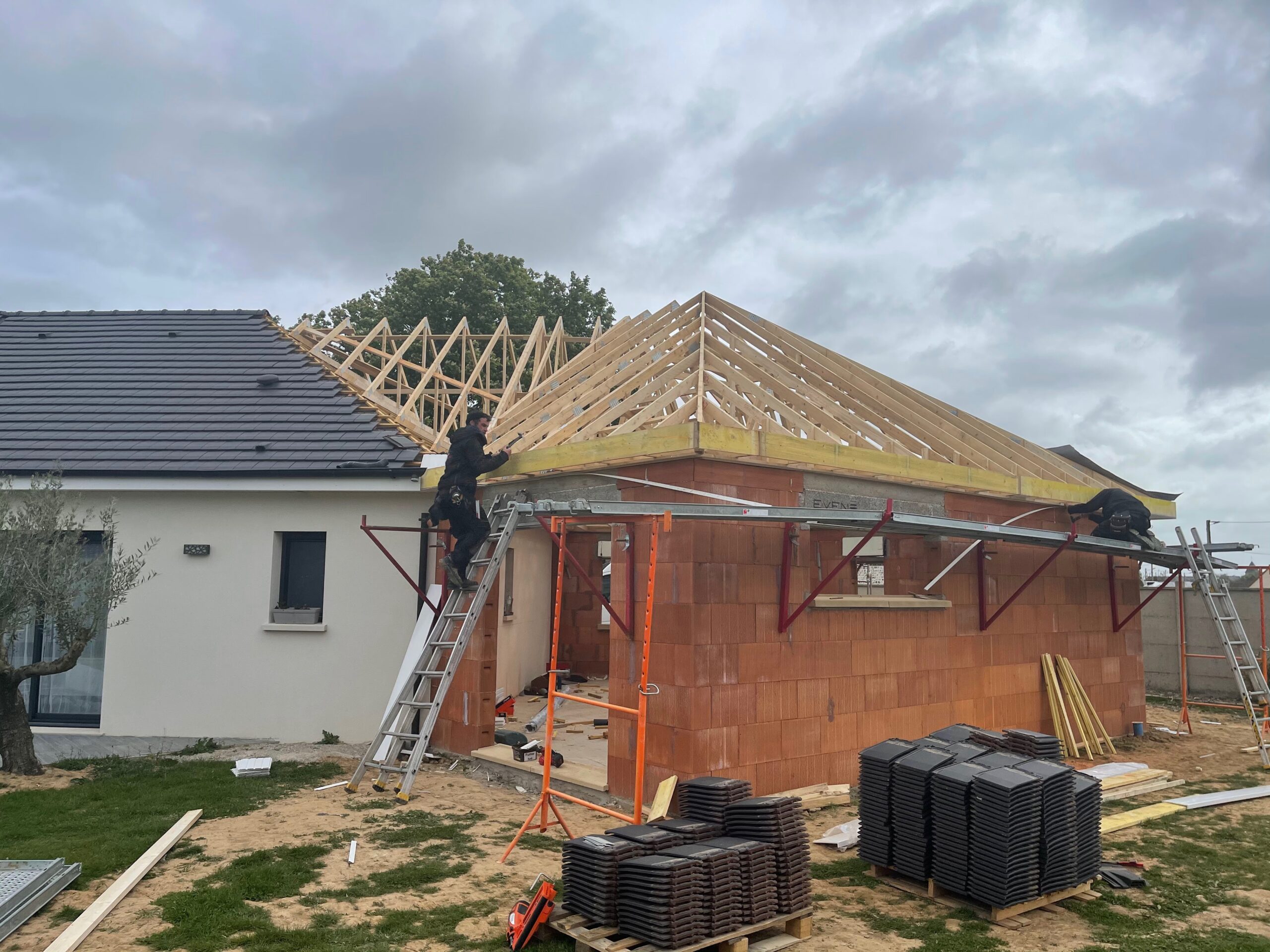 Éléments en bois pour la construction d'un toit, démontrant l'utilisation de fermes en bois dans l'architecture.