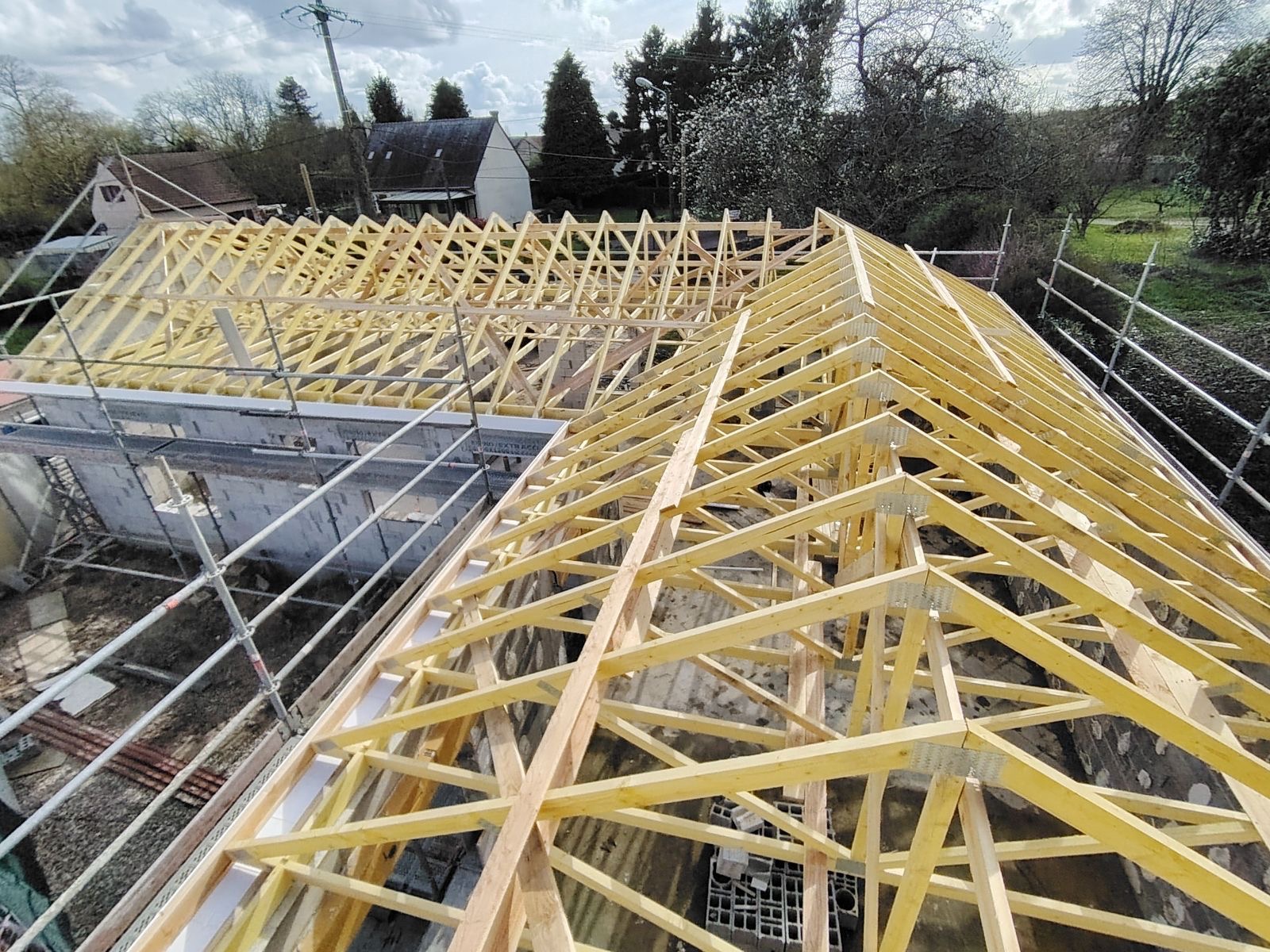 Toit en cours de construction, mettant en avant des fermes en bois, symbole de l'artisanat traditionnel